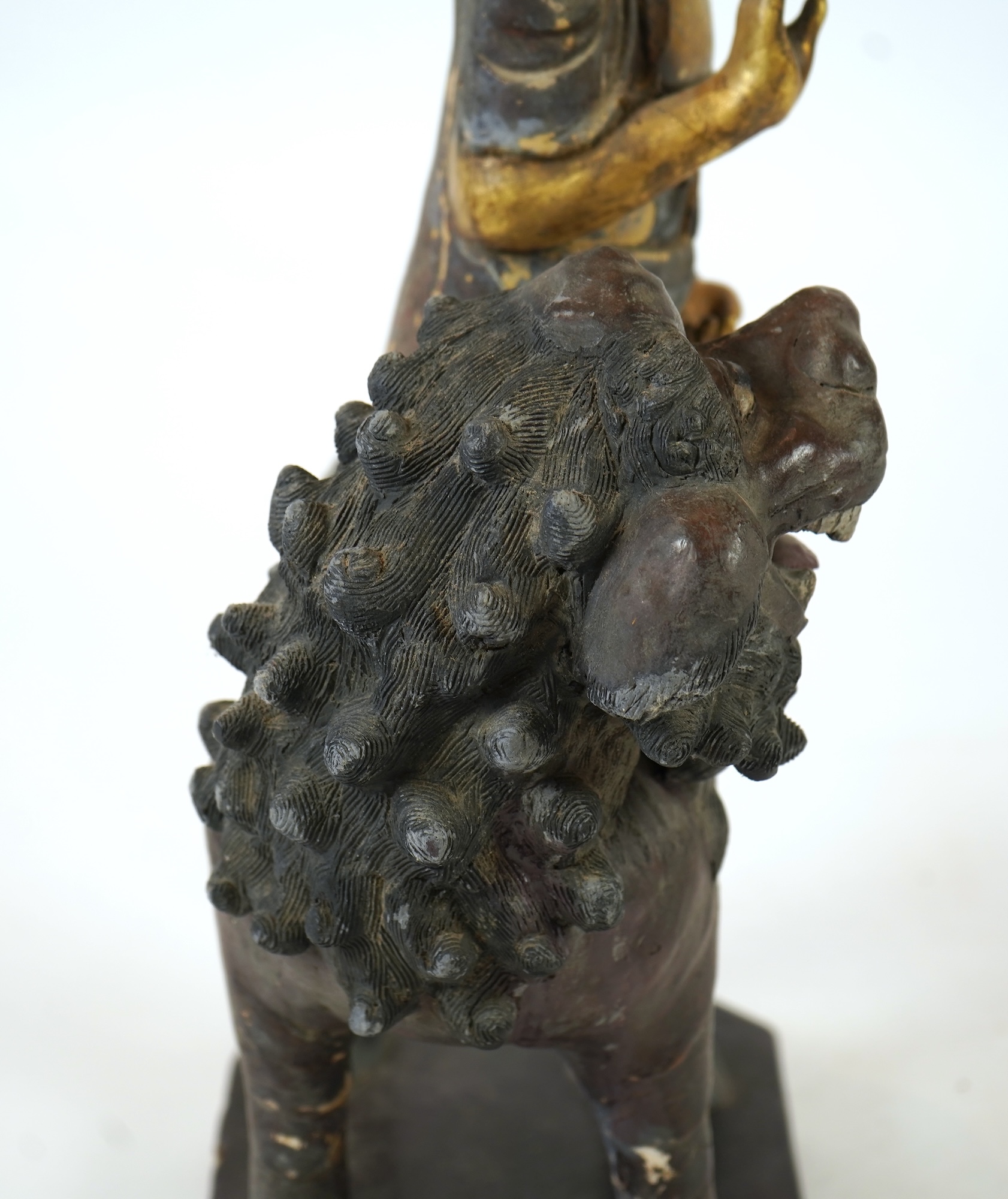 A Chinese gilt and polychrome lacquered stucco work and wood figure of Manjushri on a lion, Yuan-Ming dynasty